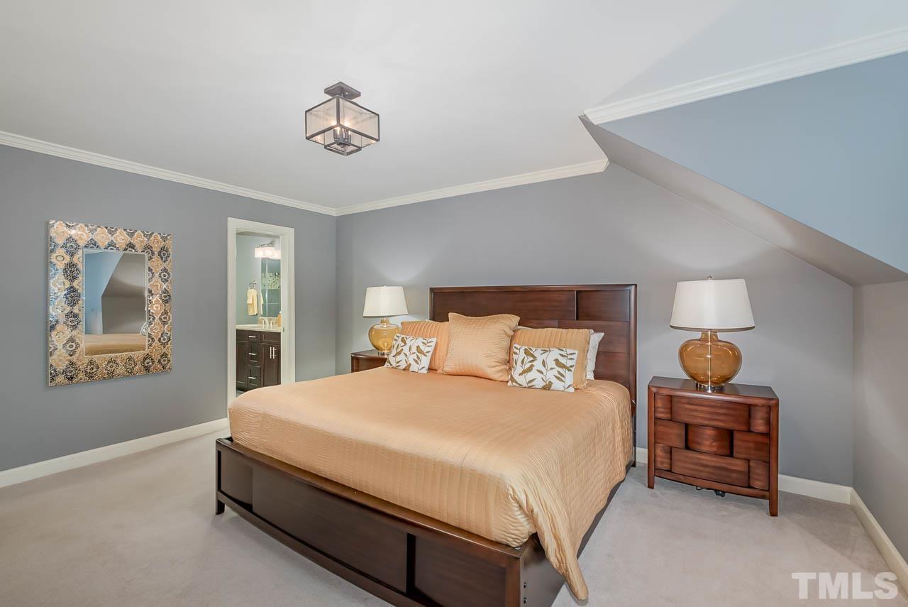 109 Nouveau Avenue Raleigh, NC 27615 - Photo 21 of 29 a bedroom with a bed and a chandelier