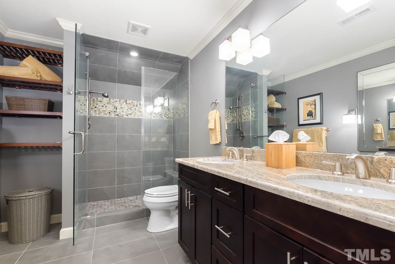 109 Nouveau Avenue Raleigh, NC 27615 - Photo 23 of 29 a bathroom with a granite countertop sink a toilet a mirror and shower
