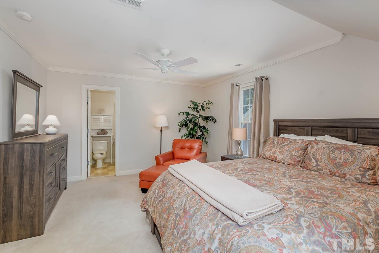 109 Nouveau Avenue Raleigh, NC 27615 - Photo 24 of 29 a bedroom with a bed and a chandelier
