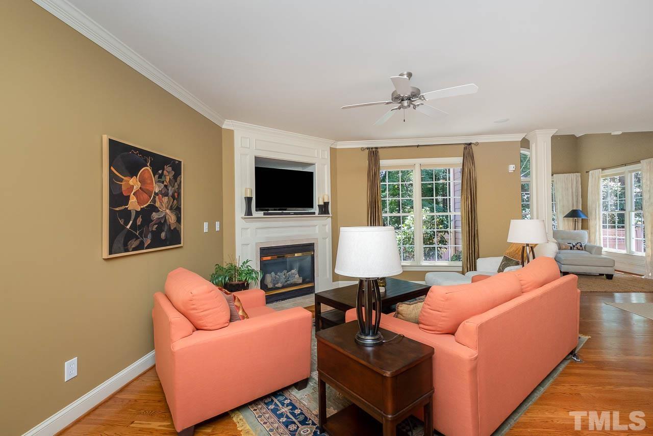 109 Nouveau Avenue Raleigh, NC 27615 - Photo 5 of 29 a living room with furniture a fireplace and a flat screen tv