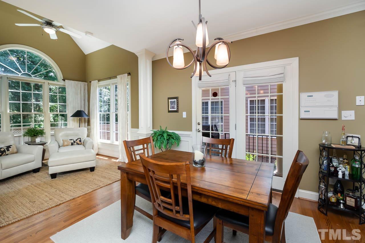 109 Nouveau Avenue Raleigh, NC 27615 - Photo 8 of 29 a dining room with wooden floor a chandelier a wooden table and chairs