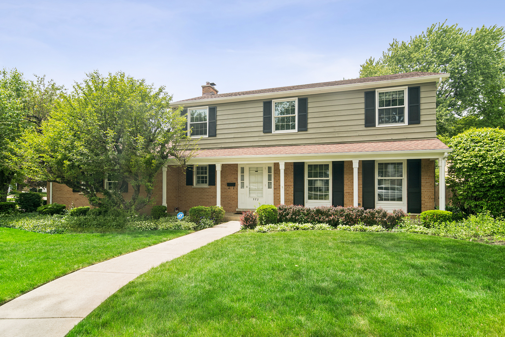 a front view of a house with a garden and plants