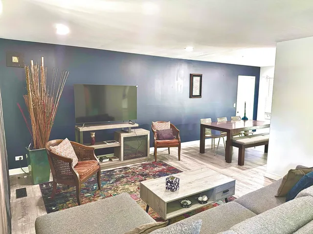 a living room with furniture a rug and a flat screen tv