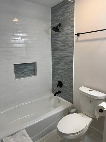 a white toilet and tub sitting next to a bathroom sink