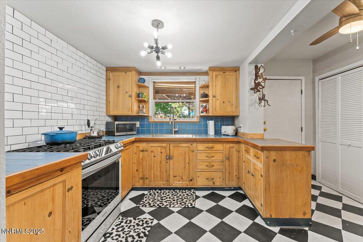 661 Thoma Street Reno, NV 89502 - Photo 9 of 33 a kitchen with stainless steel appliances a sink a stove a refrigerator and cabinets