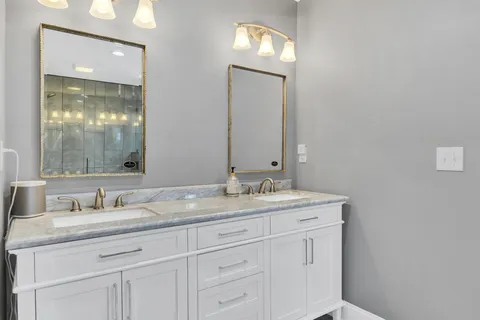 a bathroom with a granite countertop sink vanity and mirror