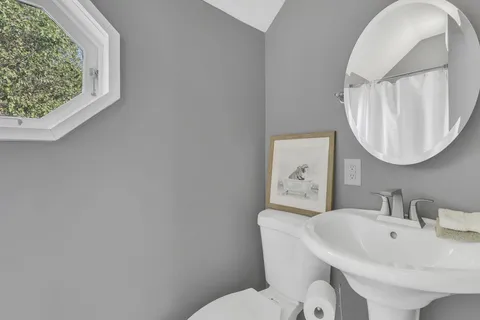 a bathroom with a toilet a sink and a mirror