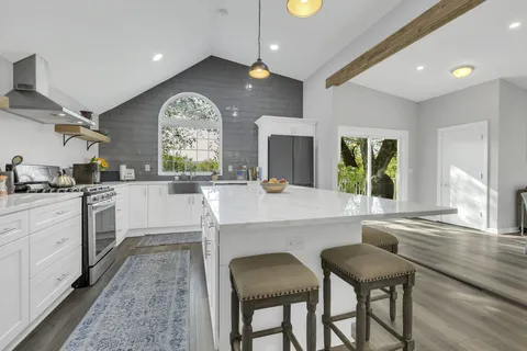 a large white kitchen with a large window