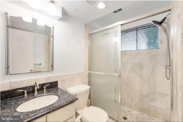 a bathroom with a sink toilet a mirror and shower