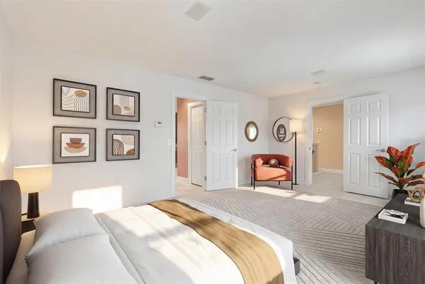 a bedroom with a bed a mirror and paintings on the wall