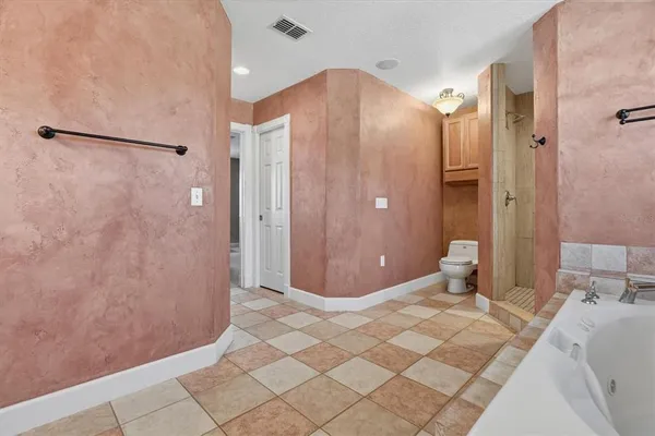 a kitchen with stainless steel appliances kitchen island granite countertop a refrigerator a stove a sink dishwasher and white cabinets with wooden floor