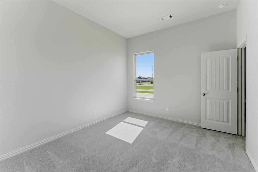 104 Snowy Owl Trail Rhome, TX 76078 - Photo 15 of 27 Interior room featuring light gray carpeting, white baseboards, and a single window offering exterior views
