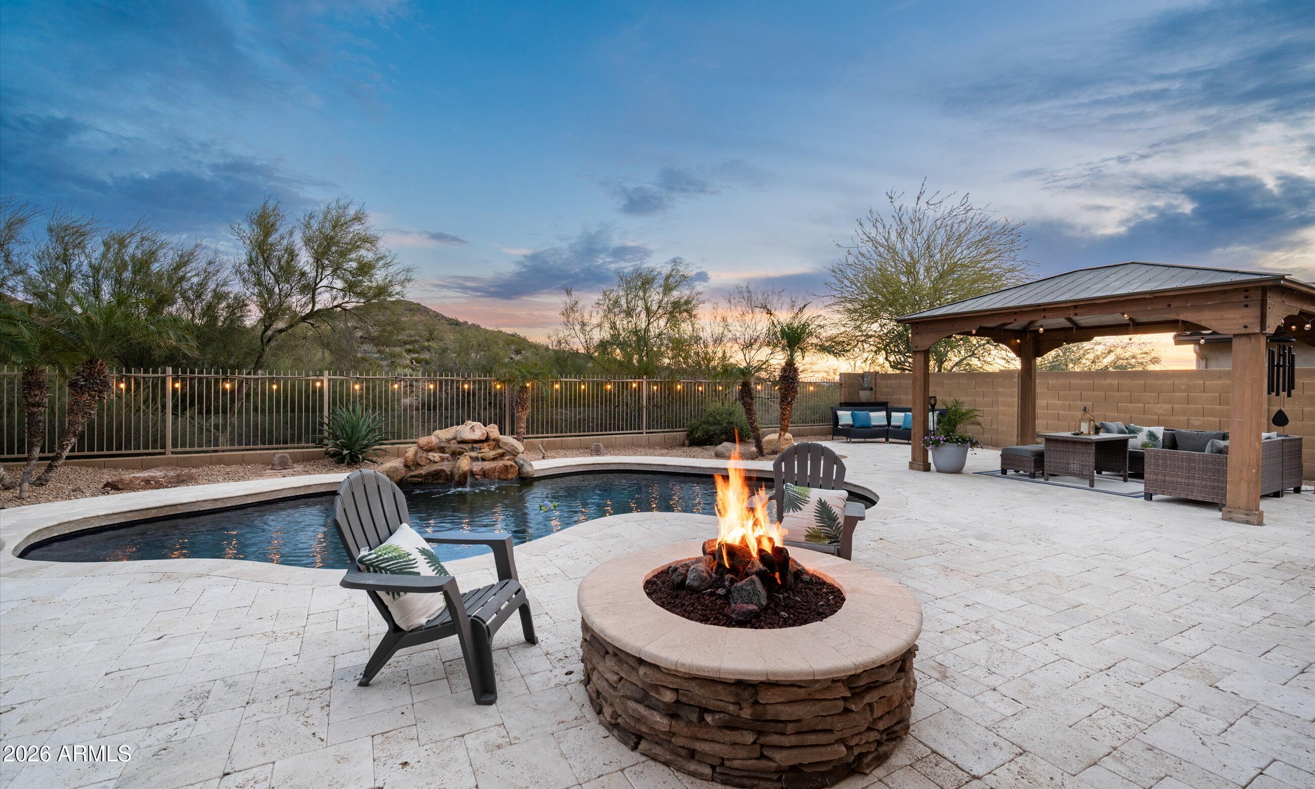 a patio with a table and chairs and a fire pit