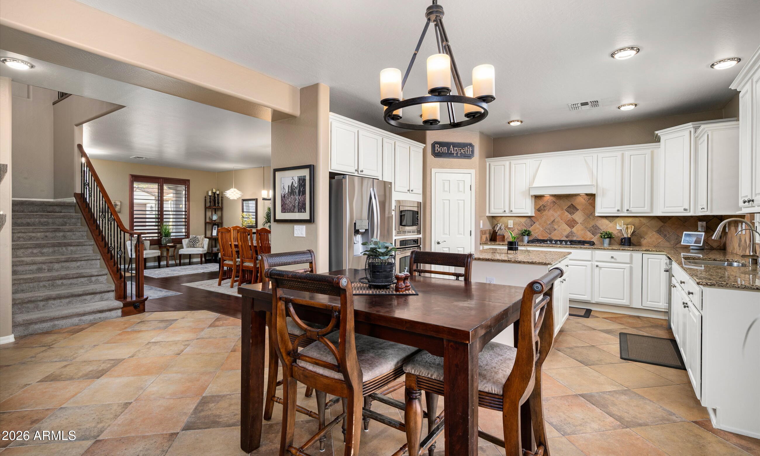 2021 West Steed Ridge Phoenix, AZ 85085 - Photo 10 of 56 a kitchen with stainless steel appliances a dining table chairs stove and cabinets