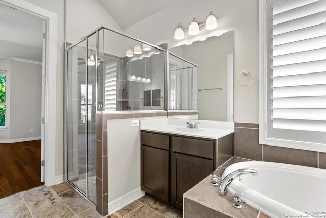 a bathroom with a sink tub vanity and a mirror