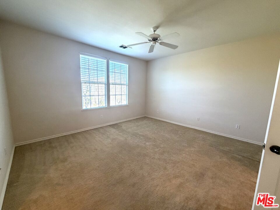 27030 Victoria Lane, Unit 76 Valencia, CA 91355 - Photo 11 of 19 an empty room with windows and chandelier fan