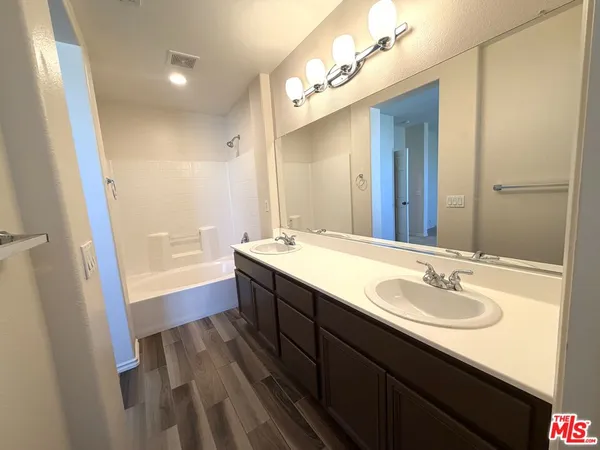a spacious bathroom with a double vanity sink and a mirror
