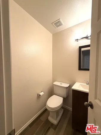 a bathroom with a toilet a sink and mirror
