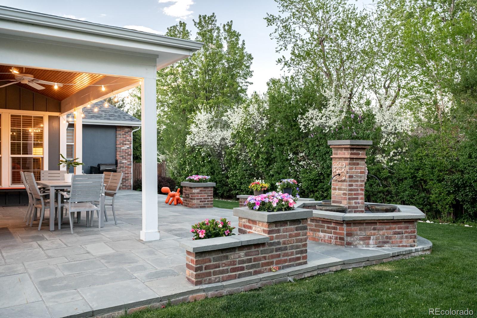 3350 Oak Street Wheat Ridge, CO 80033 - Photo 33 of 40 a front view of a house with a fountain and flower garden