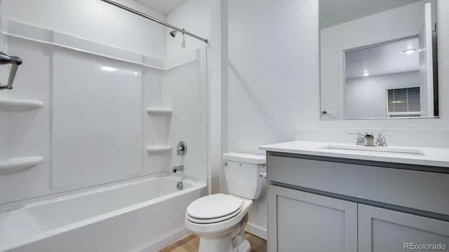 a bathroom with a sink toilet vanity and tub