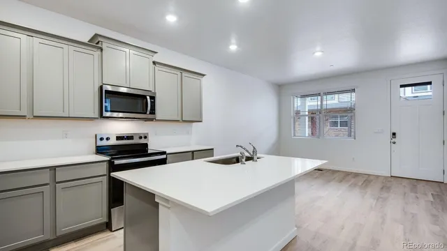 a kitchen with a sink a microwave and cabinets