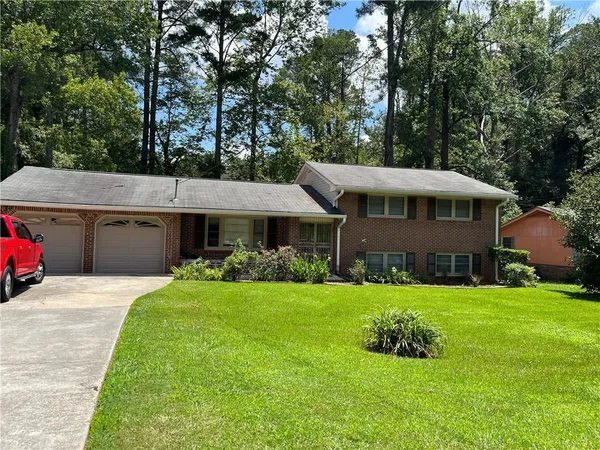 a view of a house with a yard and sitting area