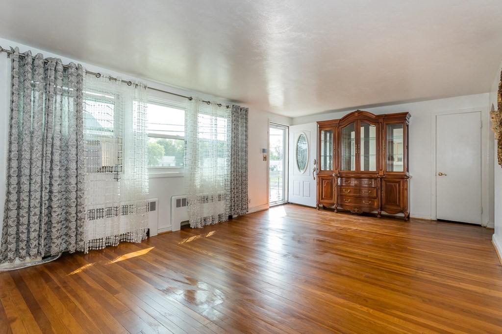 1 Desmond Road Randolph, MA 02368 - Photo 3 of 18 a view of an empty room with wooden floor and a window