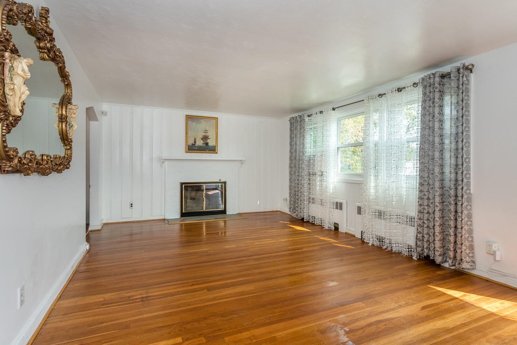 1 Desmond Road Randolph, MA 02368 - Photo 5 of 18 a view of a livingroom with wooden floor and a fireplace