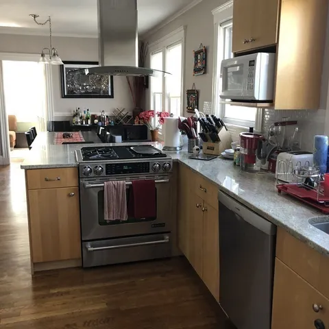 a kitchen with stainless steel appliances granite countertop a sink stove and cabinets