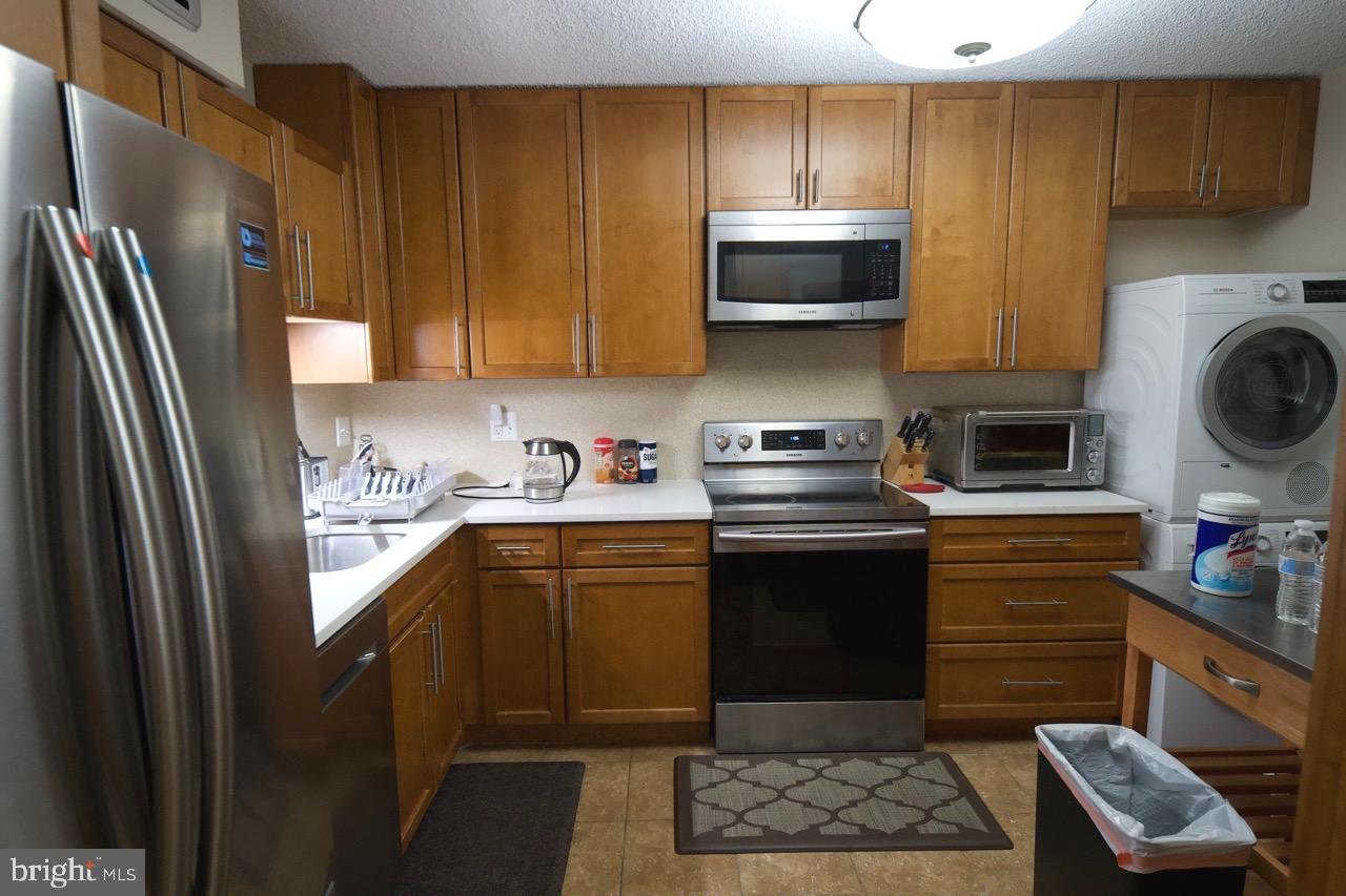 1800 Old Meadow Road, Unit 818 McLean, VA 22102 - Photo 11 of 35 a kitchen with stainless steel appliances granite countertop a refrigerator stove top oven a sink and dishwasher