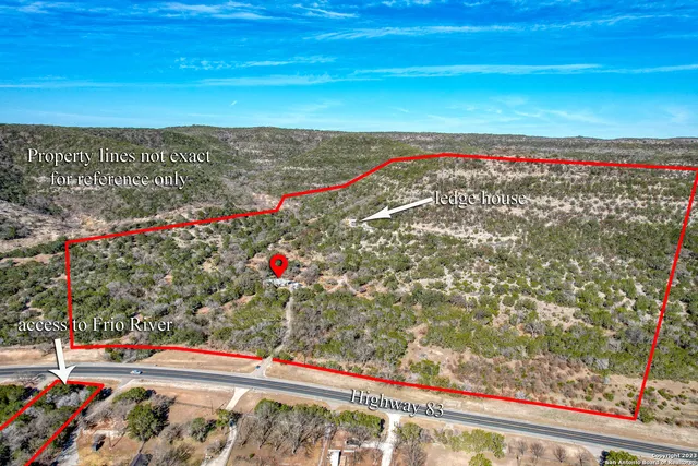 an aerial view of residential house with outdoor space and trees all around