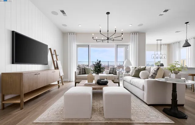 a living room with furniture a chandelier and a flat screen tv