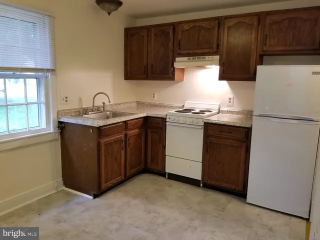 a kitchen with stainless steel appliances granite countertop a refrigerator a sink a stove a refrigerator and cabinets