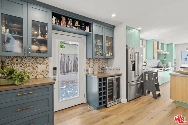 a view of kitchen with stainless steel appliances kitchen island granite countertop a refrigerator and cabinets