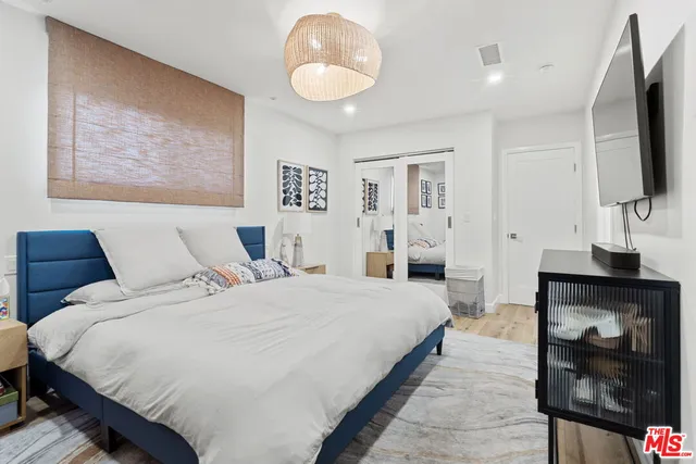 a bedroom with a bed and a chandelier