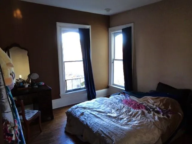 a bedroom with a bed and wooden floor