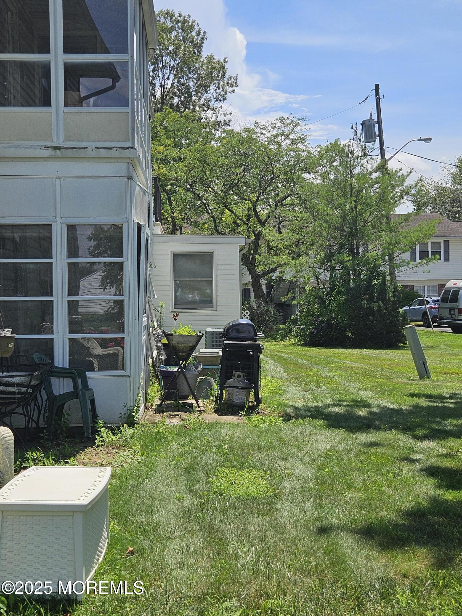72 Haven Drive, Unit 500 Matawan, NJ 07747 - Photo 16 of 19 a view of a chair and tables in the backyard