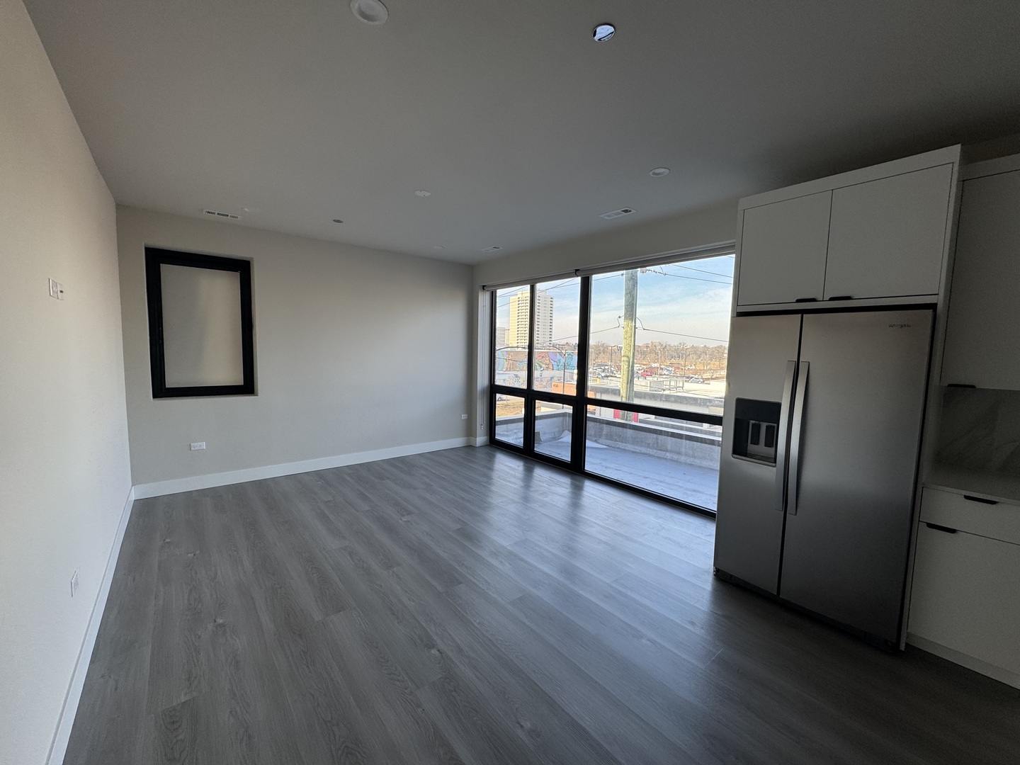 503 East Pershing Road, Unit 301 Chicago, IL 60653 - Photo 5 of 21 a view of an empty room with wooden floor and a window
