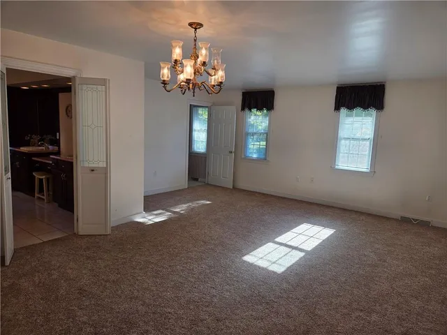 an empty room with windows and chandelier