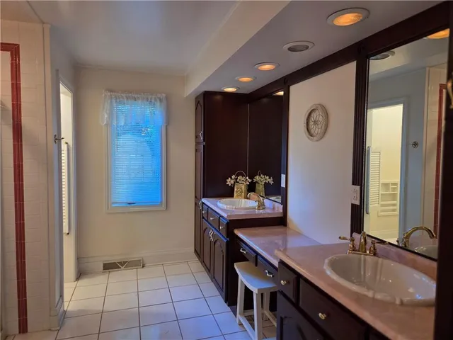 a spacious bathroom with a granite countertop sink and a mirror