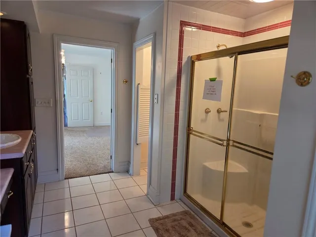 a bathroom with a glass door shower and a sink