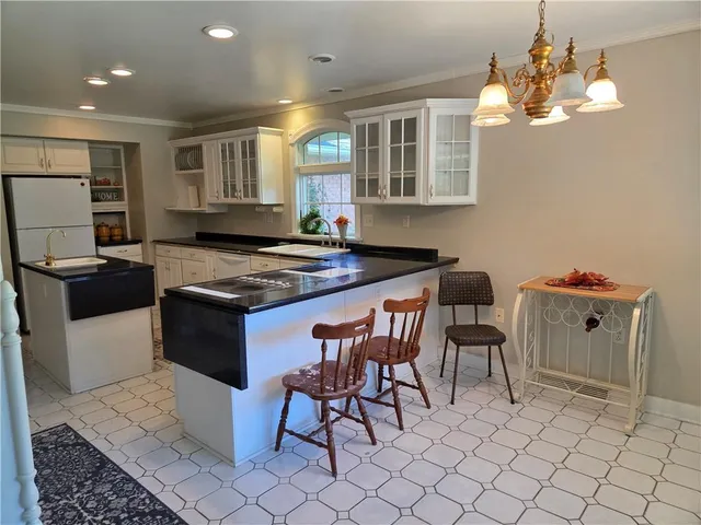 a kitchen with granite countertop a sink cabinets and stainless steel appliances