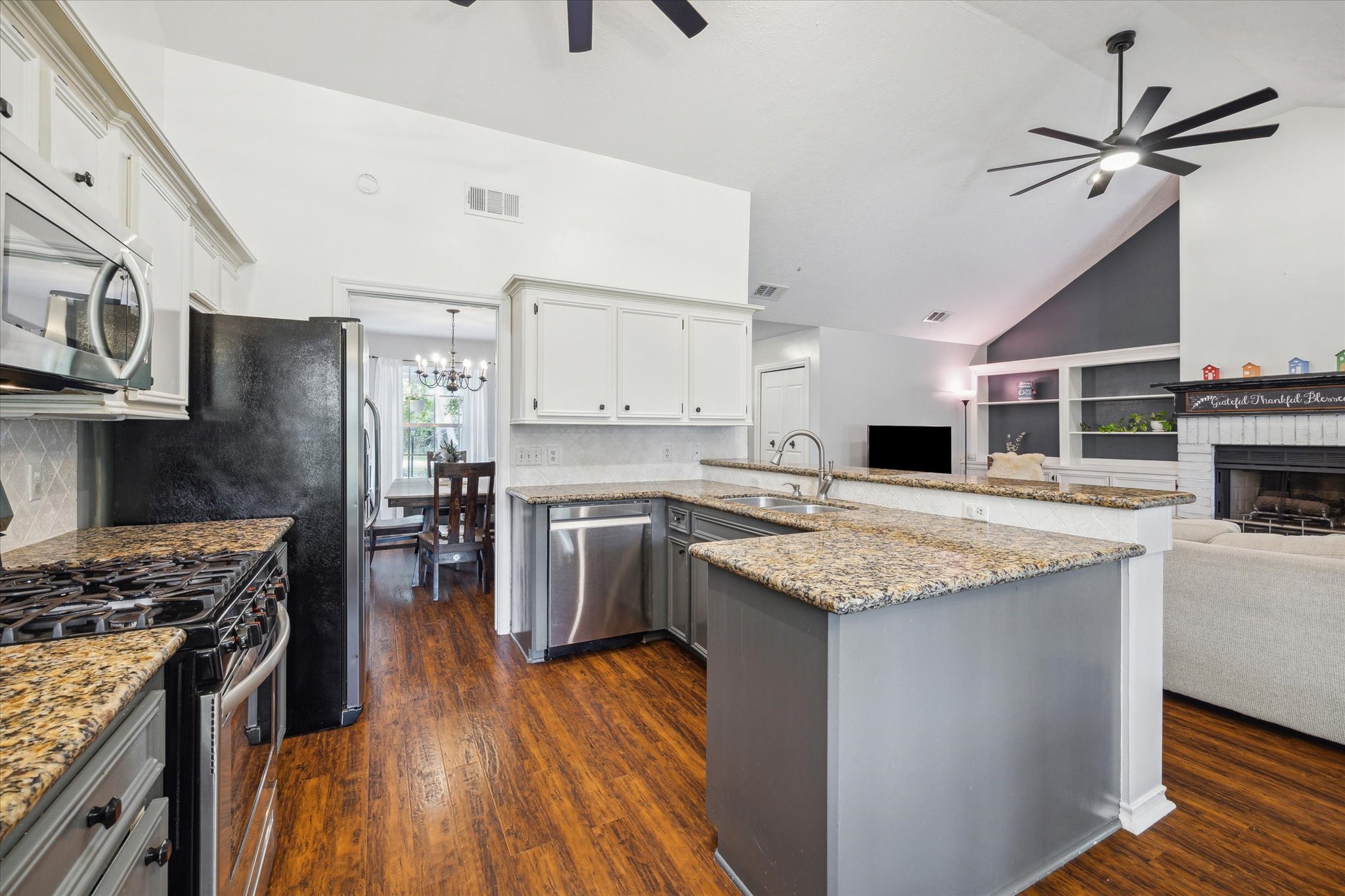 2420 Canter Lane Conroe, TX 77384 - Photo 9 of 24 a kitchen with stainless steel appliances granite countertop a stove top oven a sink a counter space and cabinets