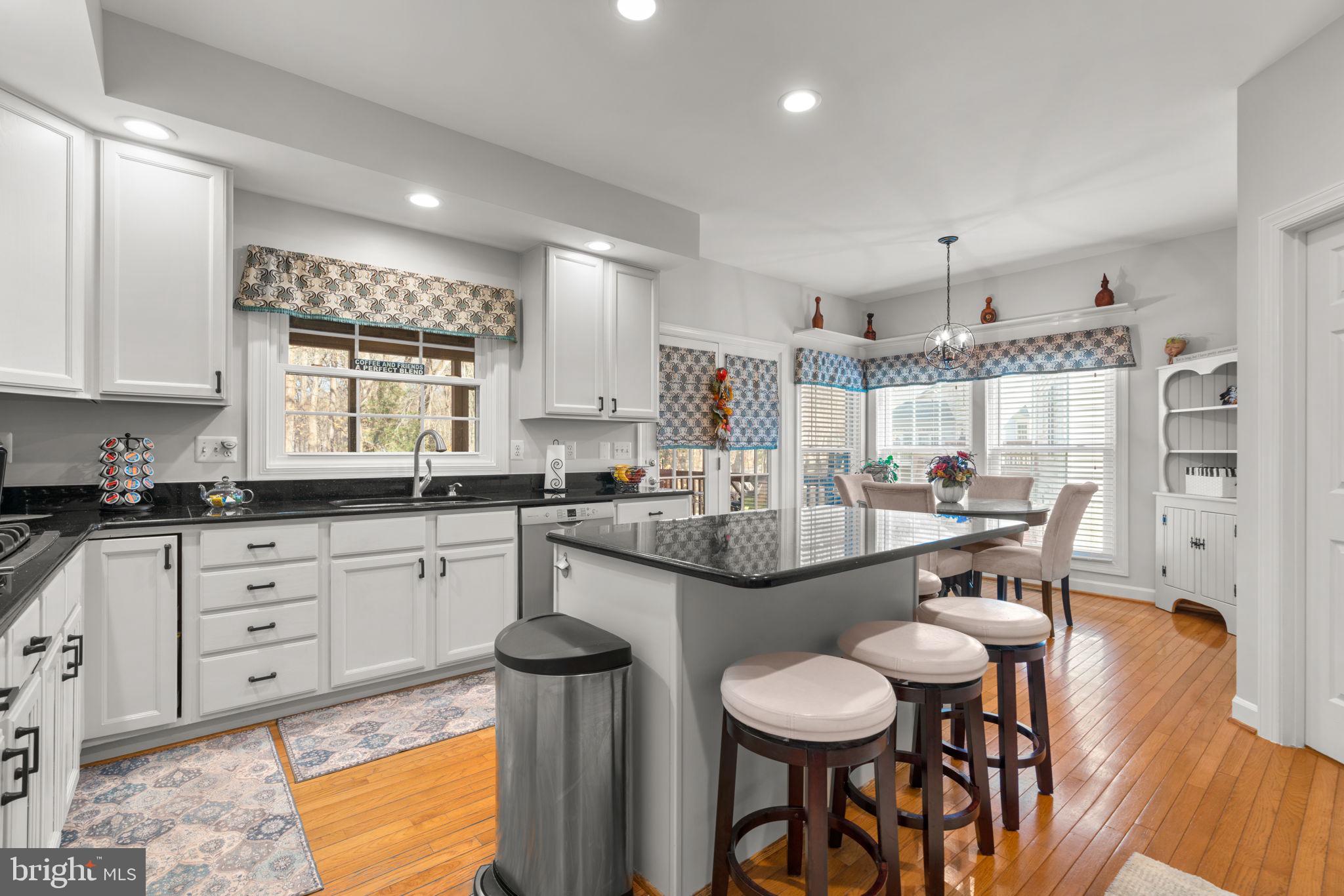 4617 Brightwood Road Olney, MD 20832 - Photo 17 of 58 a kitchen with stainless steel appliances granite countertop a table chairs sink and cabinets