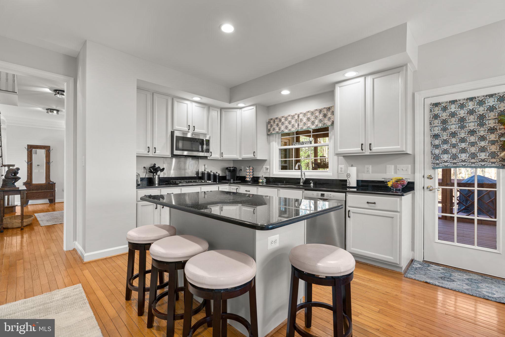 4617 Brightwood Road Olney, MD 20832 - Photo 18 of 58 a kitchen with stainless steel appliances granite countertop white cabinets and wooden floor