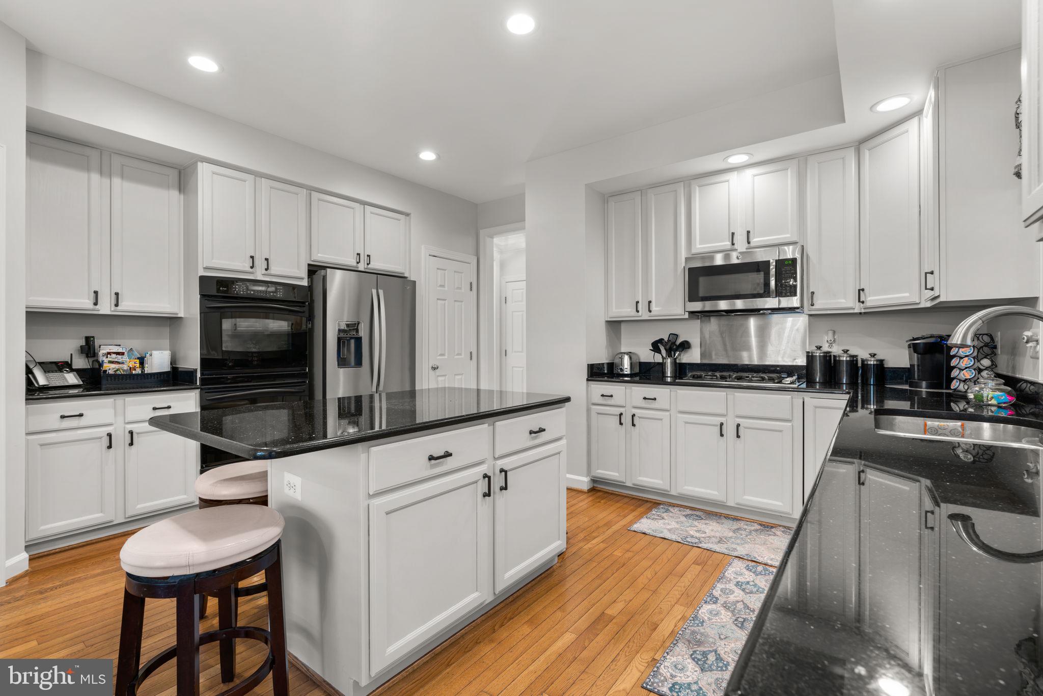 4617 Brightwood Road Olney, MD 20832 - Photo 19 of 58 a kitchen with granite countertop a refrigerator stove microwave and sink