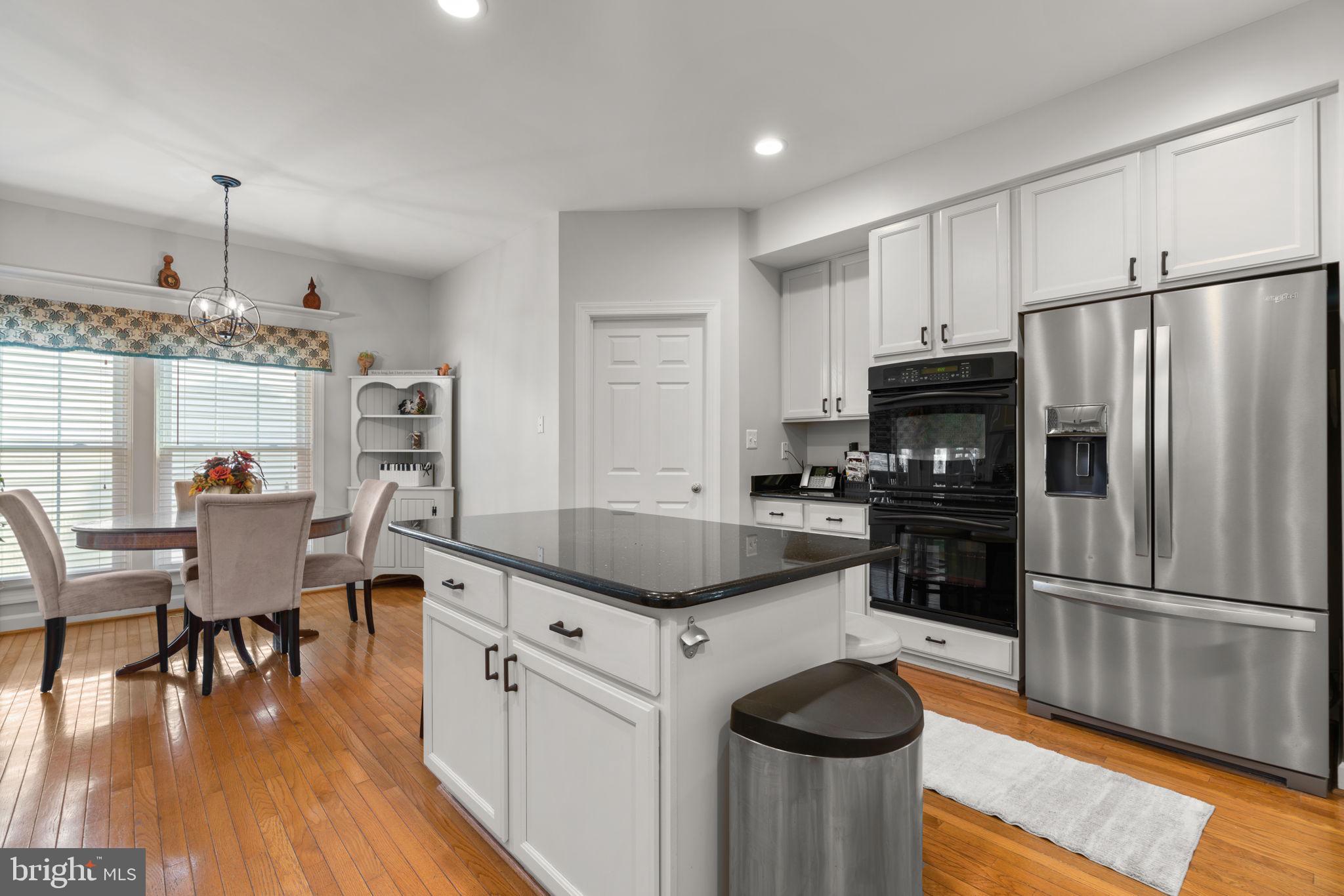 4617 Brightwood Road Olney, MD 20832 - Photo 20 of 58 a kitchen with granite countertop a table chairs stove and refrigerator