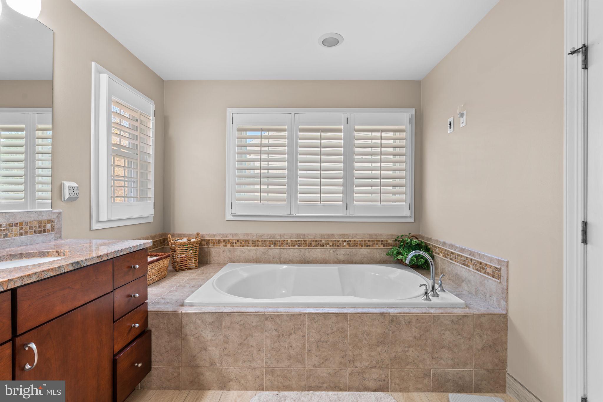 4617 Brightwood Road Olney, MD 20832 - Photo 31 of 58 a bath tub sitting in a bathroom next to a window