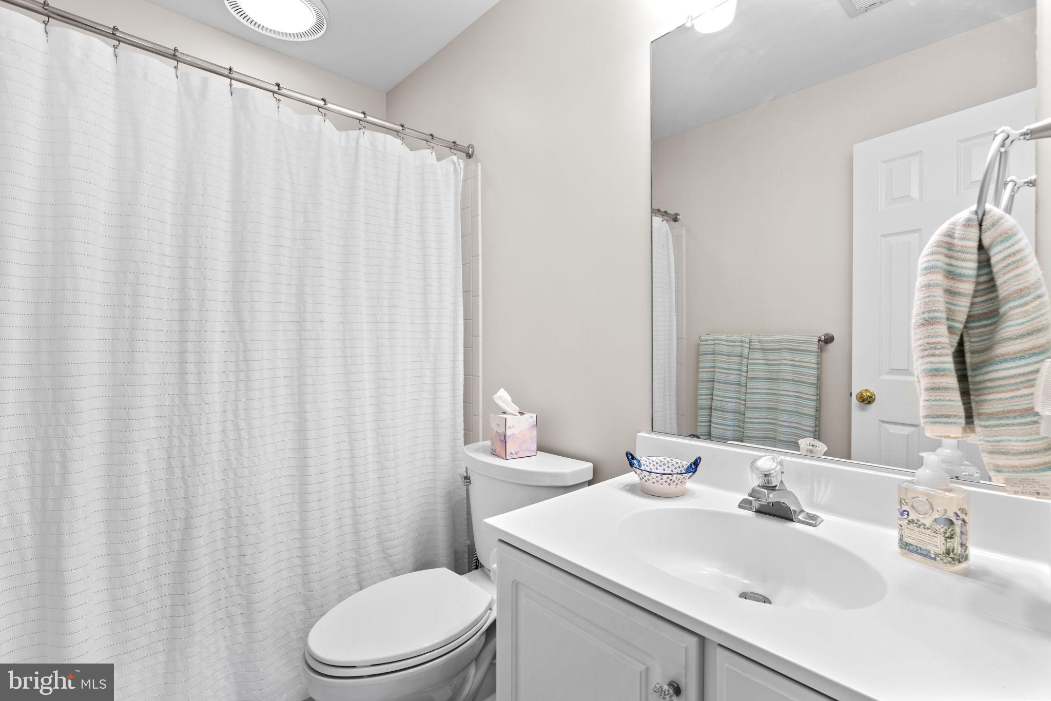 4617 Brightwood Road Olney, MD 20832 - Photo 38 of 58 a bathroom with a sink a toilet and shower curtain