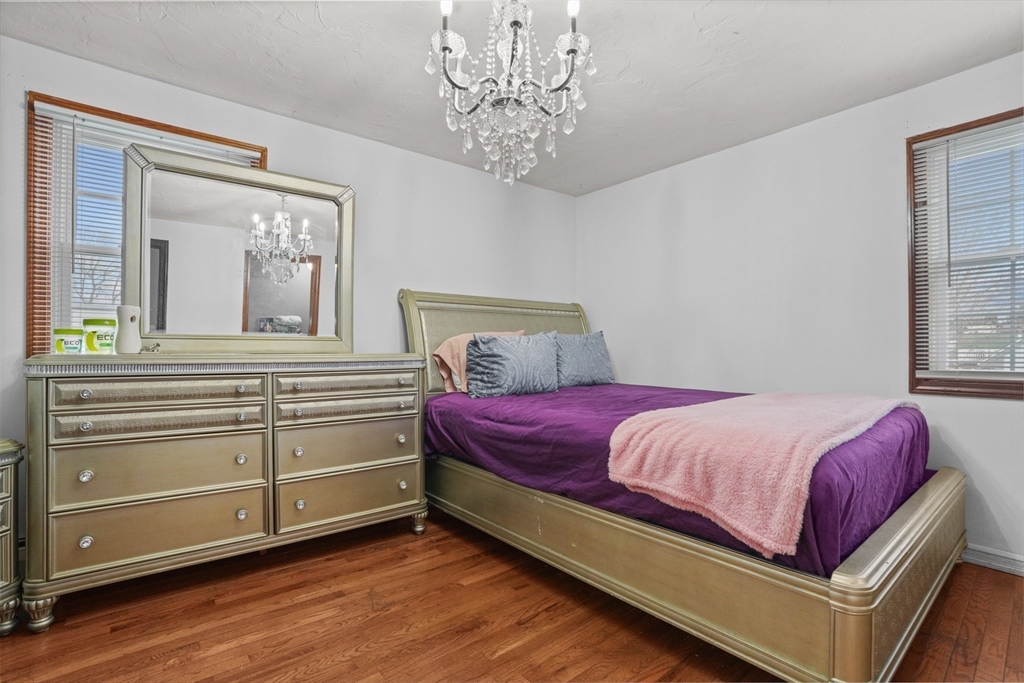 500 Hancock Street Fall River, MA 02721 - Photo 17 of 33 a bedroom with a large bed and a chandelier